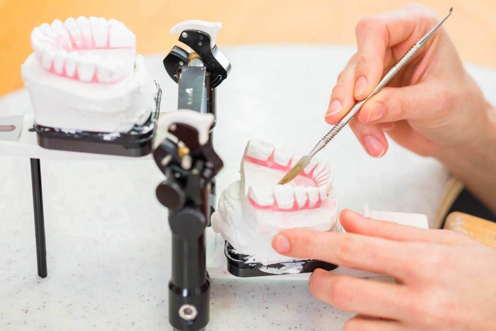 Dental lab worker working on a dentures onon isolated background